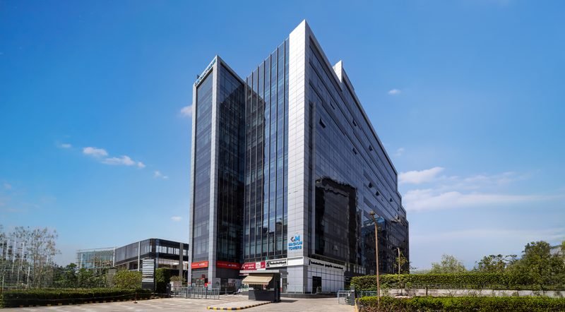 The glass façade of Magnum Towers, Tower I, seen from the campus drive